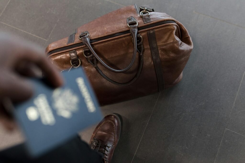 pexels-photo-1058959-1058959-1 Brown leather bag with passport in an airport setting, ideal for travel and fashion themes.