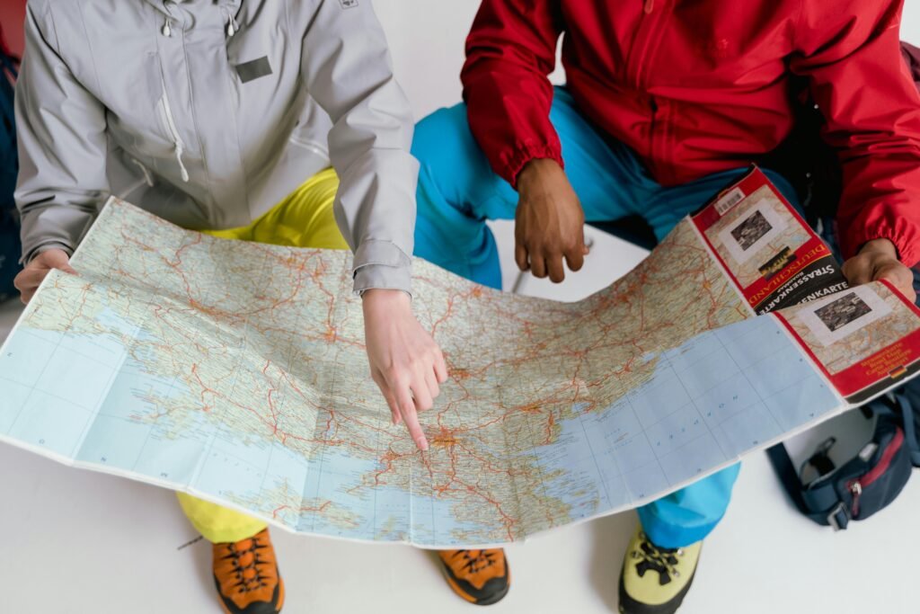 pexels-photo-7009470-7009470 Two travelers examining a detailed map for a winter hiking adventure.