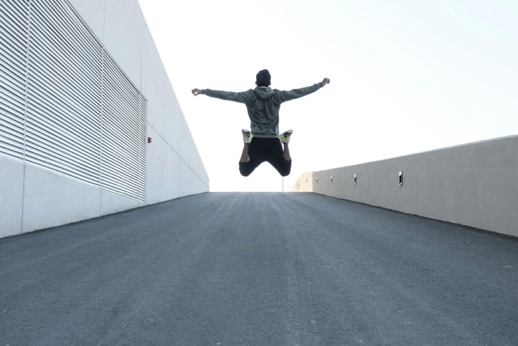 pexels-photo-1432580-1432580 Man jumping on urban road with arms spread wide in Dubai, showcasing freedom and energy.