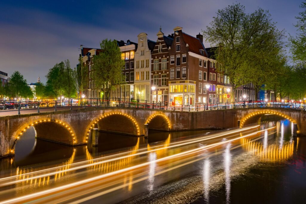 pexels-photo-3962978-3962978 Captivating long exposure of illuminated Amsterdam canal and historic buildings at night.