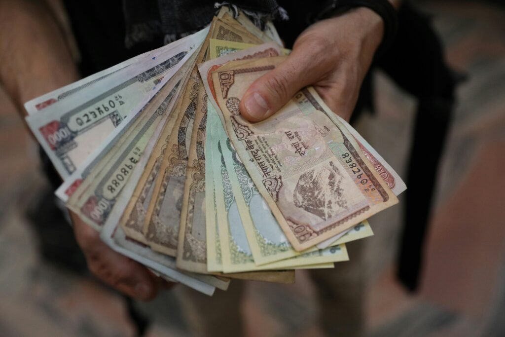 pexels-photo-6085721-6085721 A close-up of hands holding a fan of Nepalese rupee banknotes showcasing various denominations.