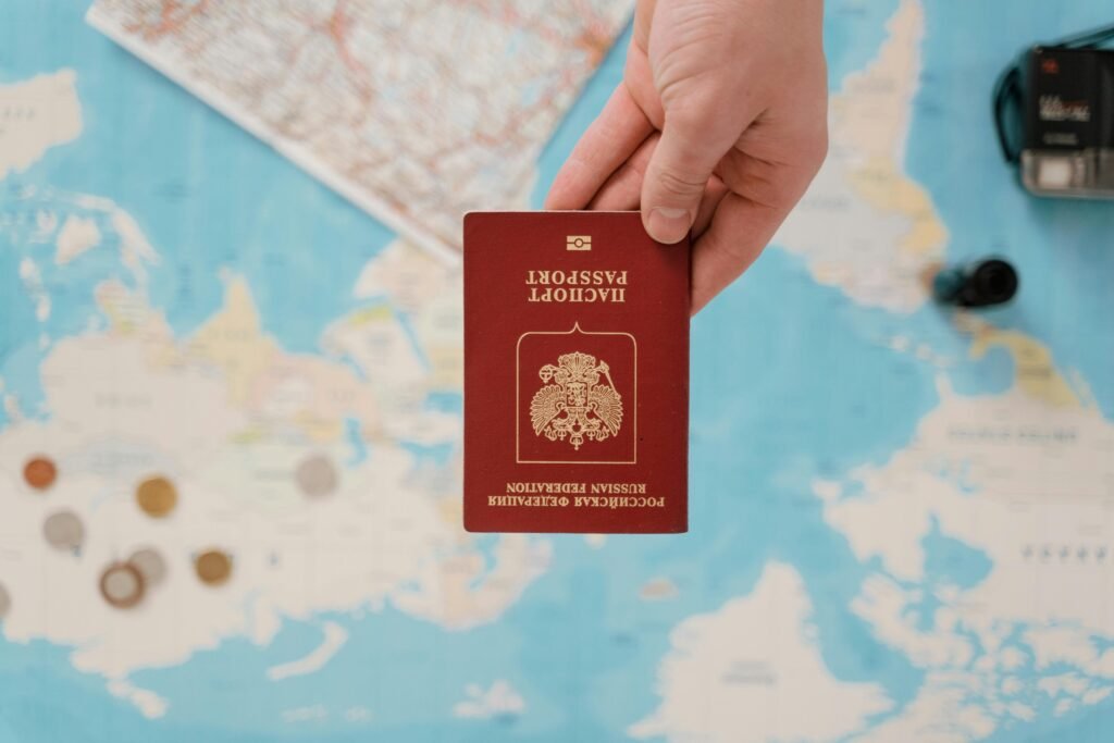 pexels-photo-7010140-7010140 A hand holding a Russian passport above a travel-themed map, capturing world travel concepts.