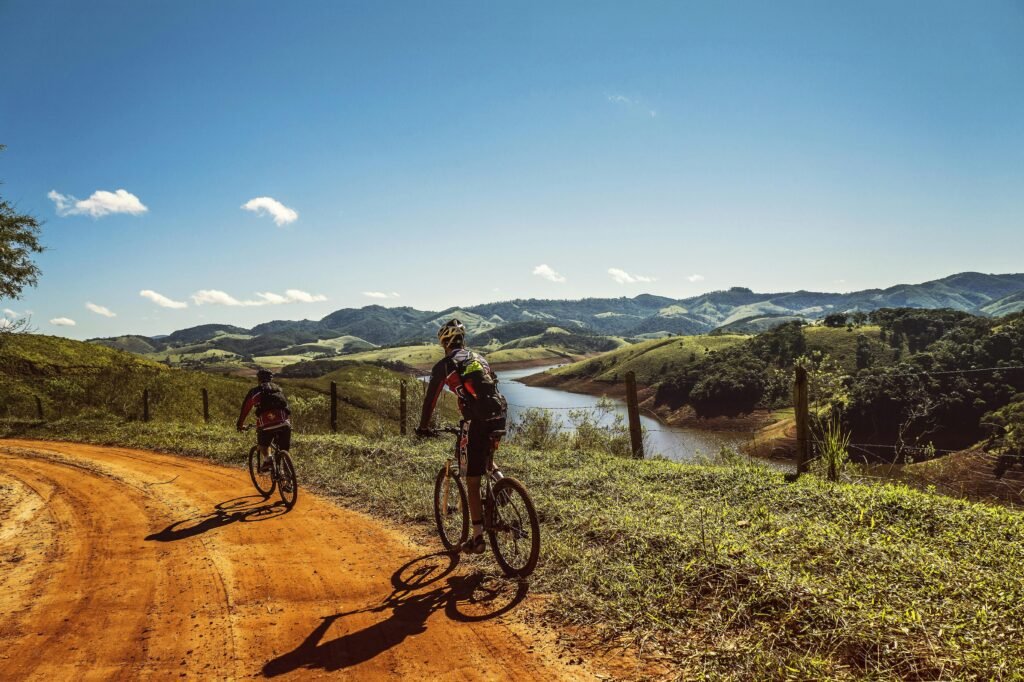 cyclists-trail-bike-clouds-163407-163407 Two cyclists riding on a dirt trail with stunning mountain views and clear skies.