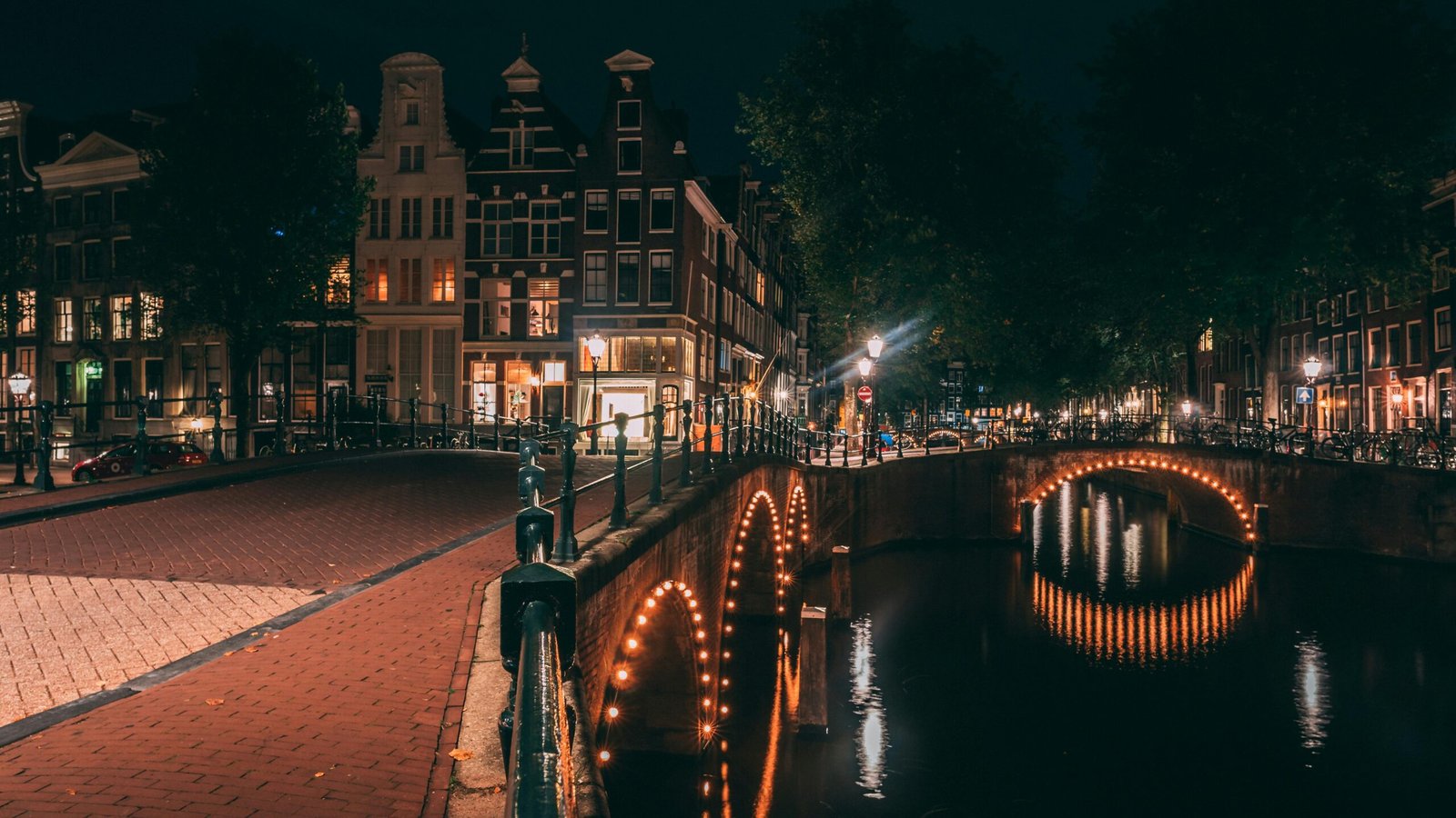 pexels-photo-1796710-1796710 Captivating view of Amsterdam's canal and illuminated bridges at night showcasing urban charm.