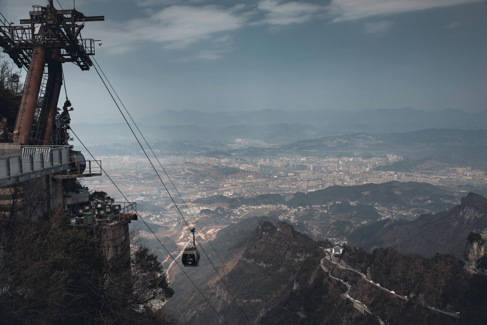 pexels-photo-25000728-25000728 Panoramic view from a cable car in Zhangjiajie, showcasing stunning mountain and city landscapes.