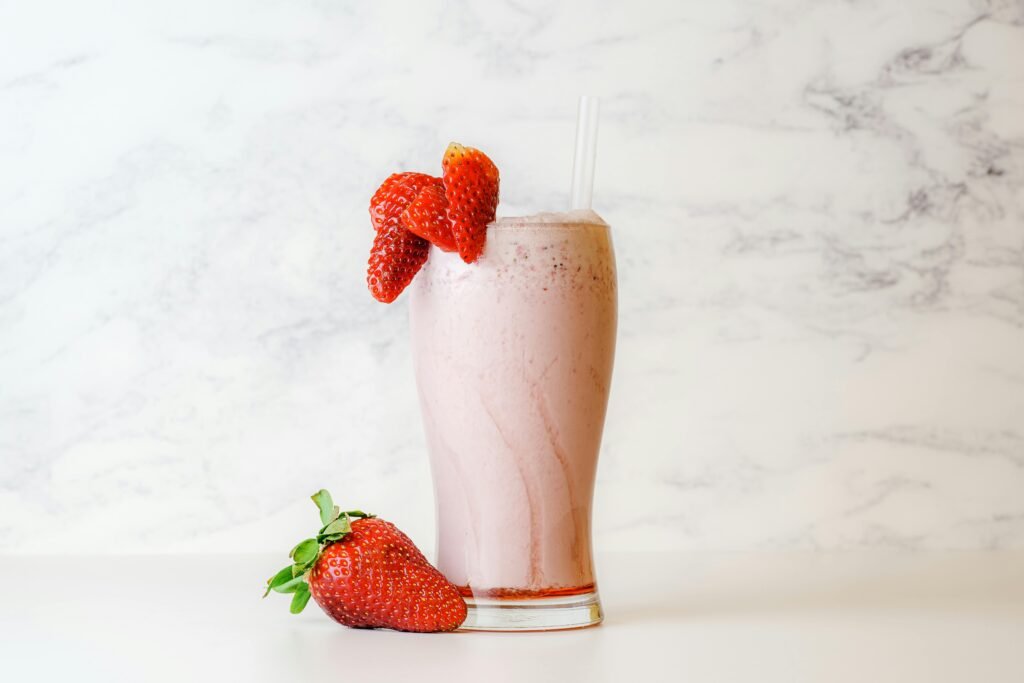 pexels-photo-3625372-3625372 Delicious and creamy strawberry milkshake garnished with fresh berries on a white marble background.