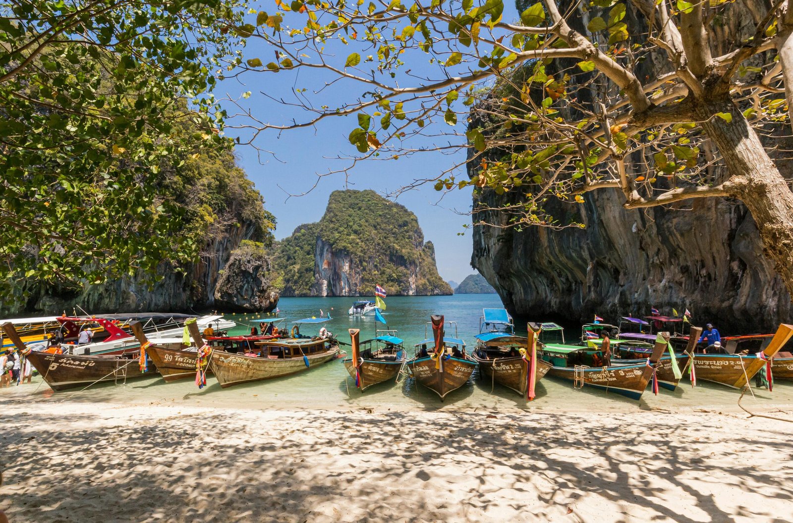 pexels-photo-3732494-3732494 Idyllic beach scene with boats docked at Krabi, Thailand, and beautiful rock formations.