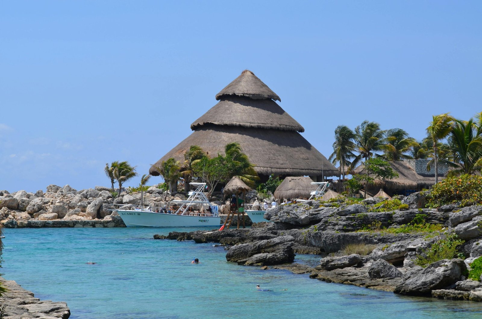 pexels-photo-8634514-8634514 Idyllic view of Xcaret Park beach with traditional hut and turquoise waters, perfect for a tropical getaway.