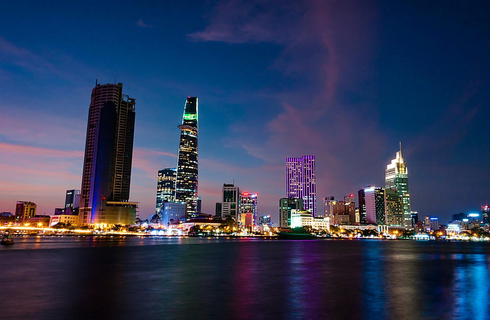 pexels-photo-941195-941195 A stunning evening view of Ho Chi Minh City's skyline reflecting vibrant lights over the Saigon River.