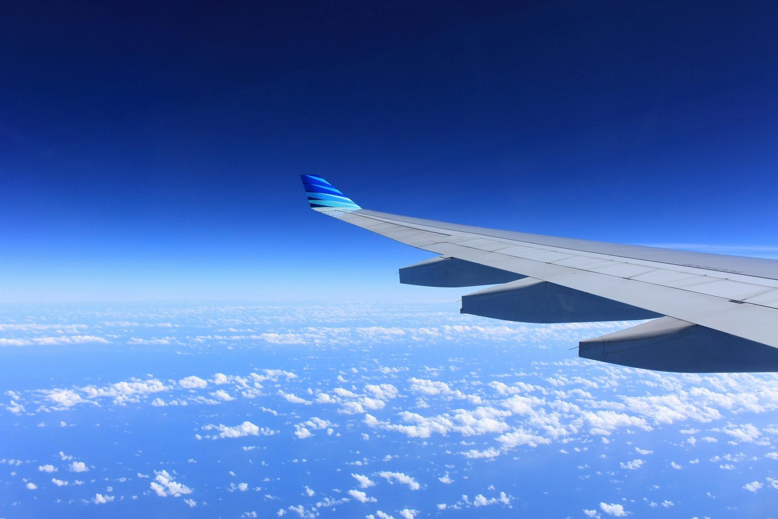 wing-plane-flying-airplane-62623-62623 Scenic view of an airplane wing flying high above the clouds on a clear day.