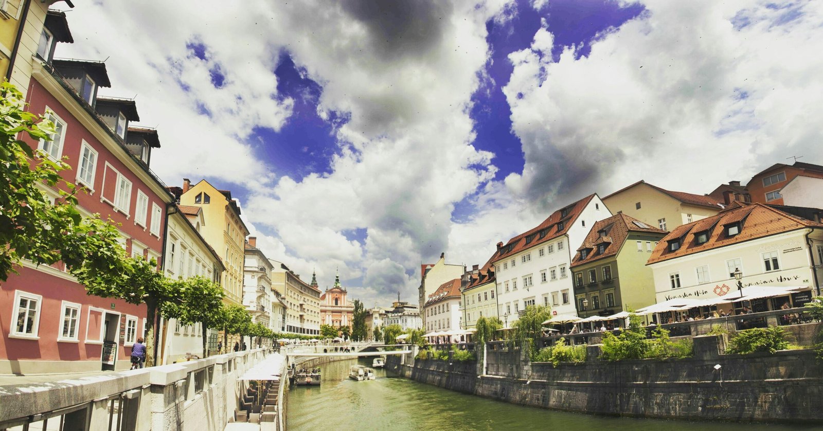 pexels-photo-111773-111773 Scenic view of colorful riverside buildings in Ljubljana, showcasing vibrant architecture under dramatic skies.