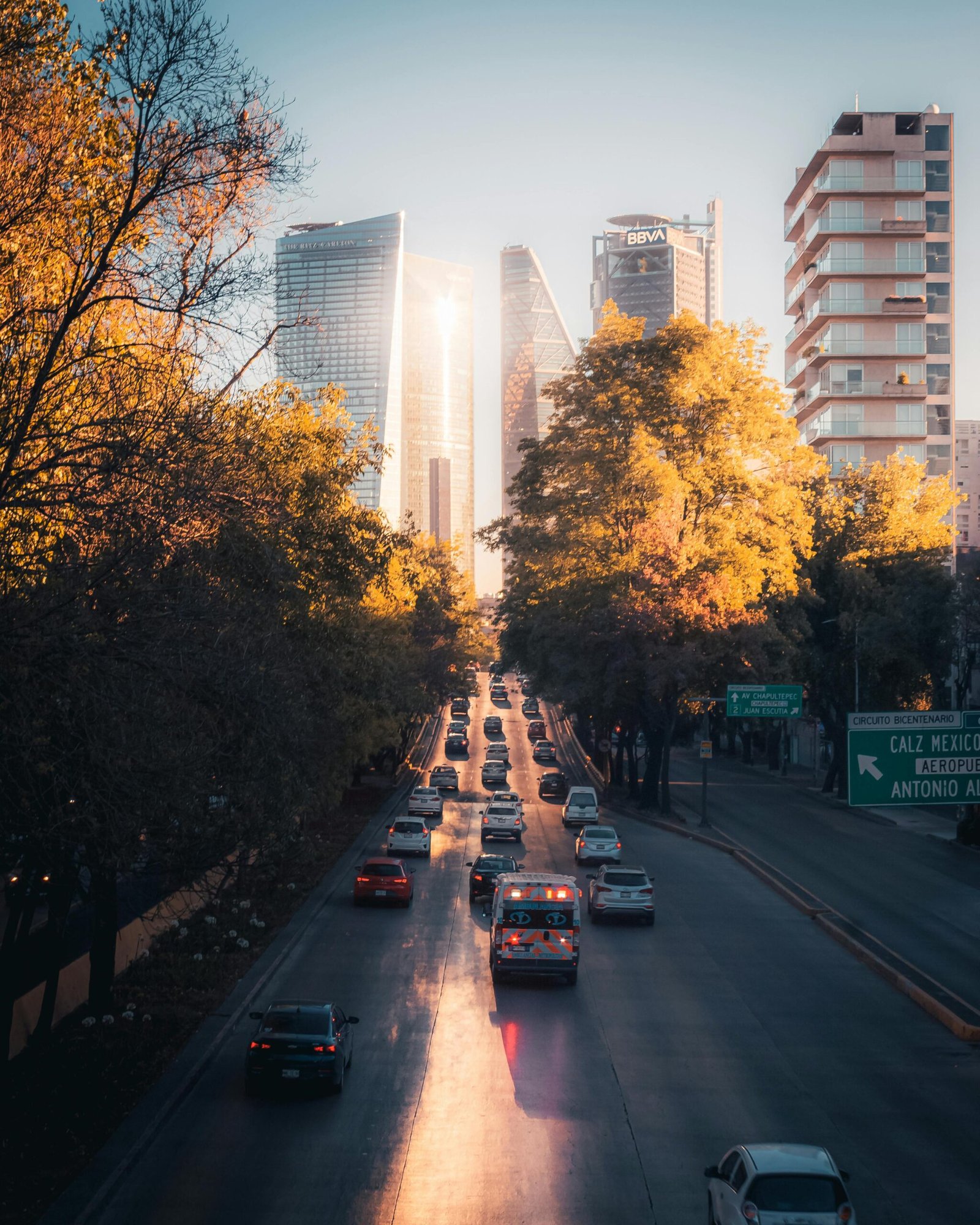 pexels-photo-12627431-12627431 A vibrant Mexico City street scene at sunset with skyscrapers and traffic, capturing urban life.