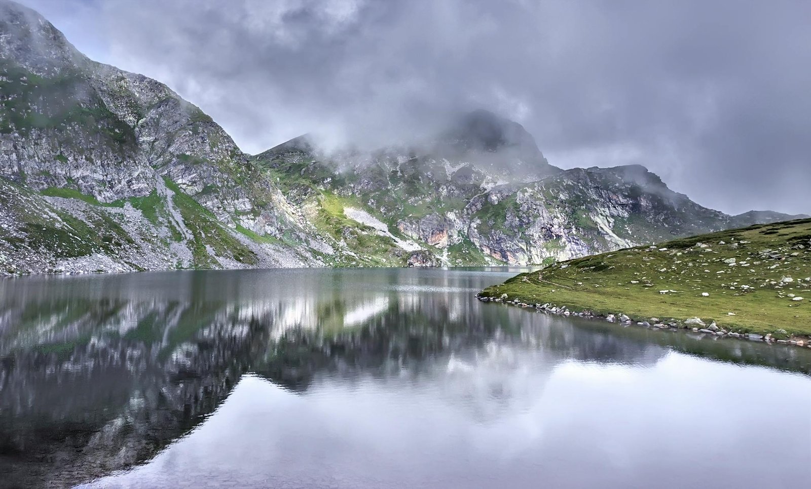 pexels-photo-163912-163912 Scenic view of a tranquil lake surrounded by misty mountains in the Rila Mountains, Bulgaria.
