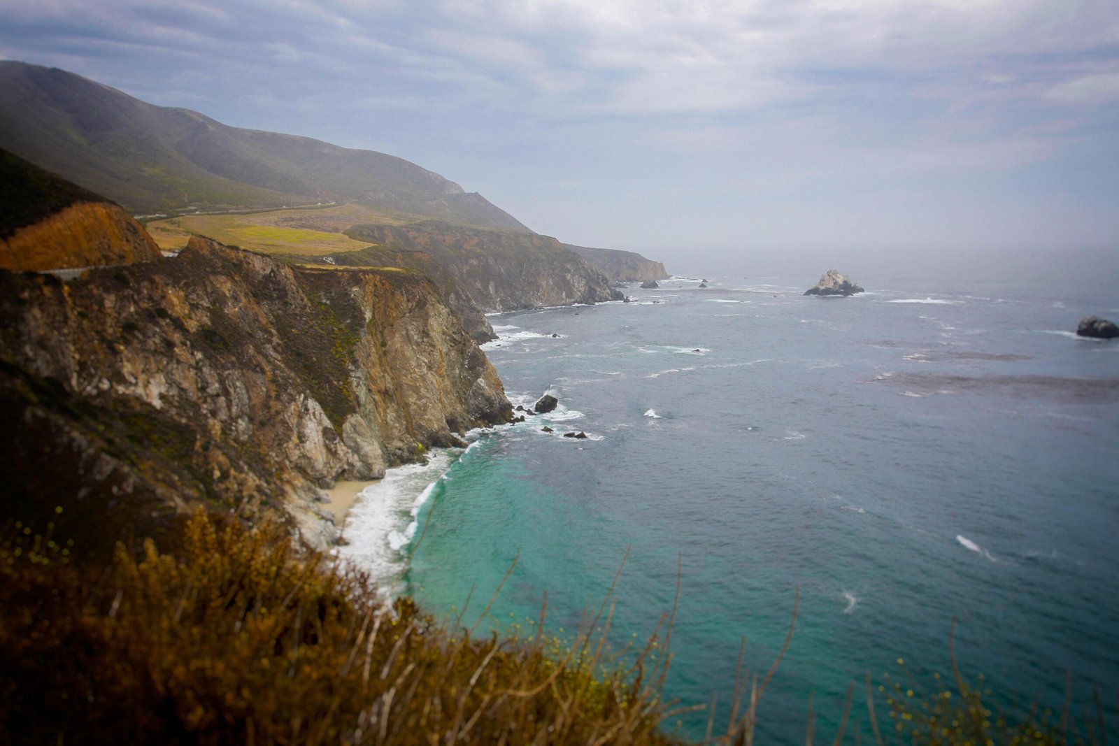 pexels-photo-1643580-1643580 Stunning seascape of cliffs meeting the ocean under a cloudy sky in Soledad, California.
