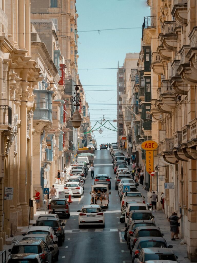 Dynamic view of a lively street in Valletta, Malta, showcasing historic architecture and urban life.