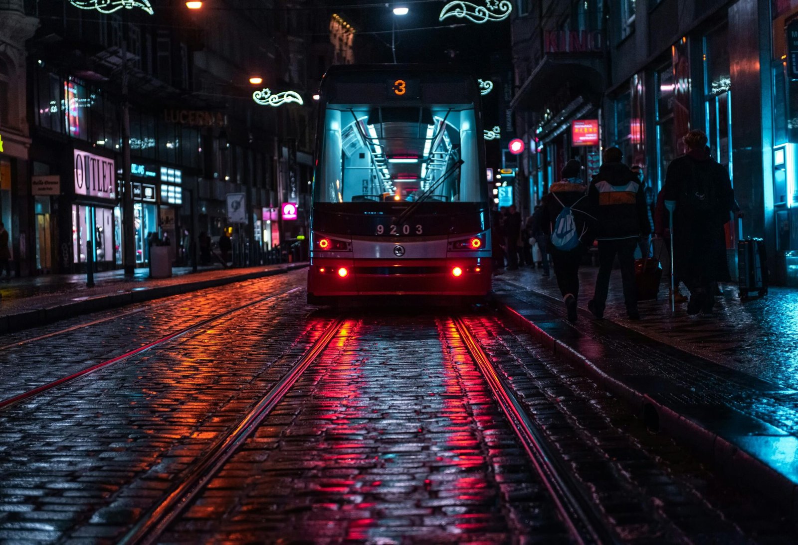 pexels-photo-1830217-1830217 Tram on a cobblestone street in Prague, reflecting city lights on a rainy evening.
