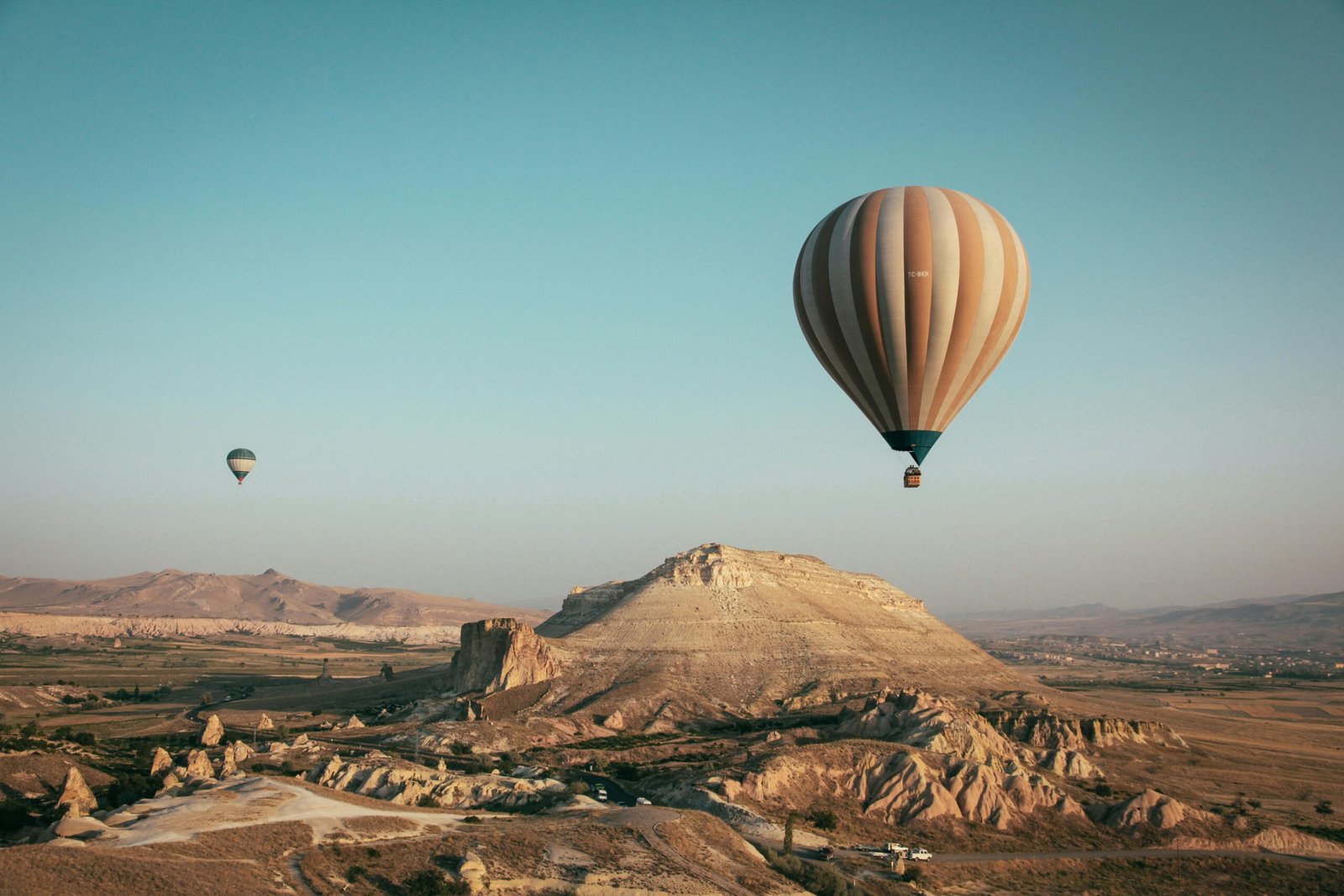 pexels-photo-2325447-2325447 Hot air balloons float over the mesmerizing landscape of Cappadocia, Turkey at sunrise.
