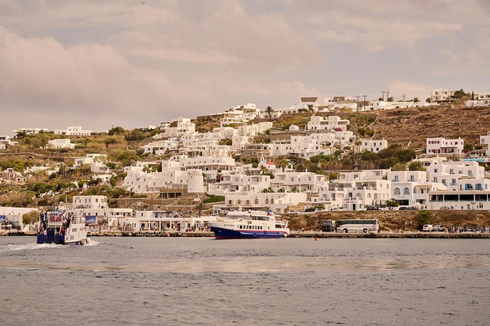 pexels-photo-24449063-24449063 Charming coastal town with white buildings on a hill and ferries in the sea.