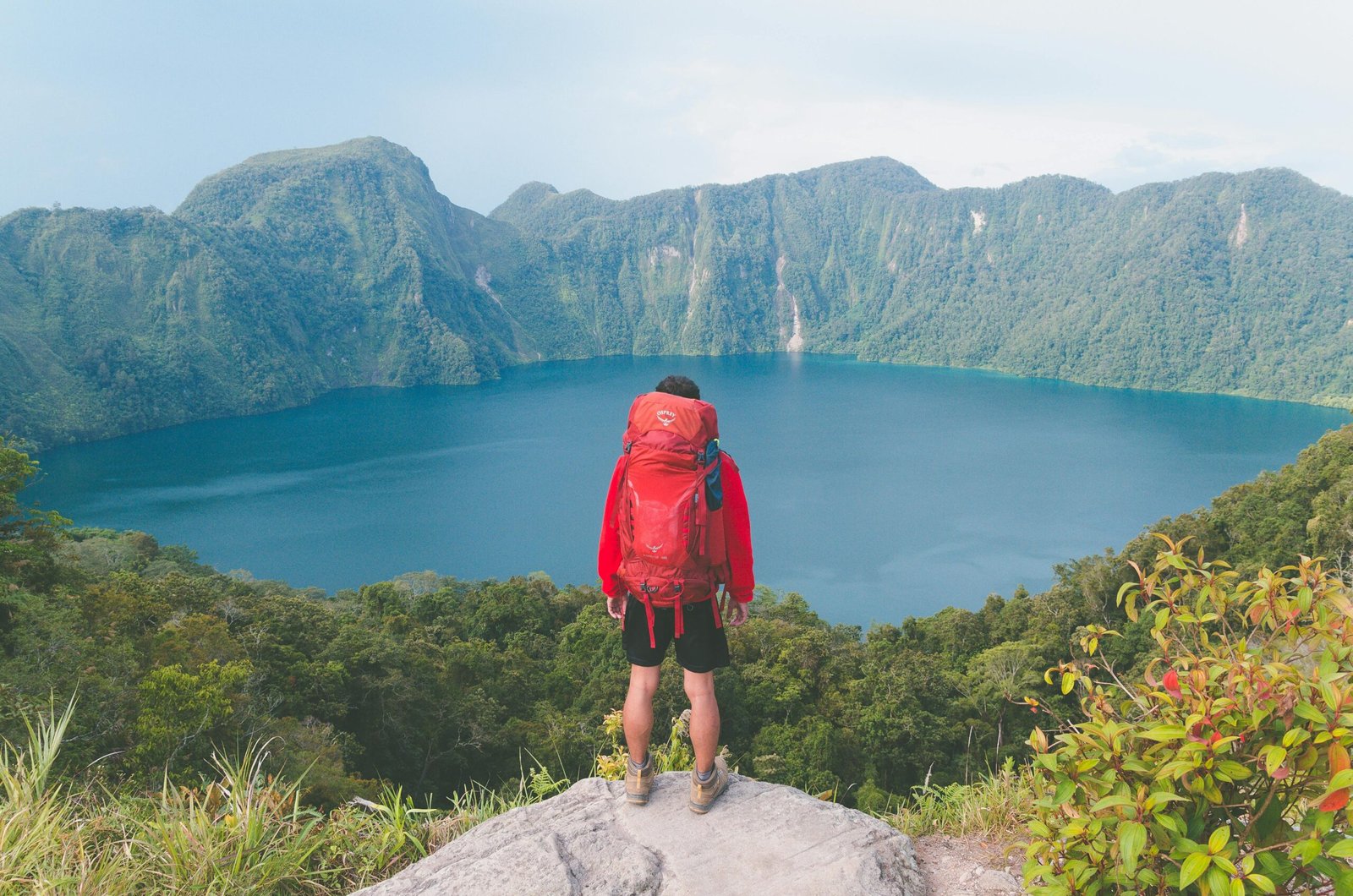 pexels-photo-2517748-2517748 Hiker with backpack enjoying scenic mountain lake view on a bright summer day.
