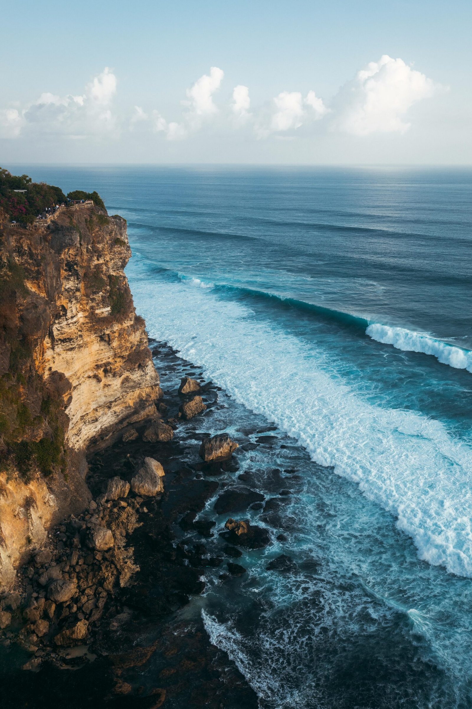 pexels-photo-2707645-2707645 A breathtaking aerial view of Bali's rugged coastline showcasing waves crashing against towering cliffs under a clear sky.