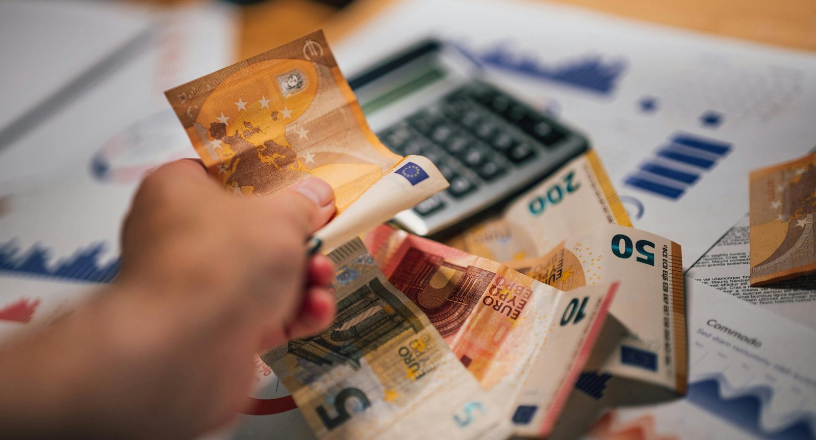 pexels-photo-28763701-28763701 Close-up of Euro banknotes on financial documents and a calculator, depicting financial planning.