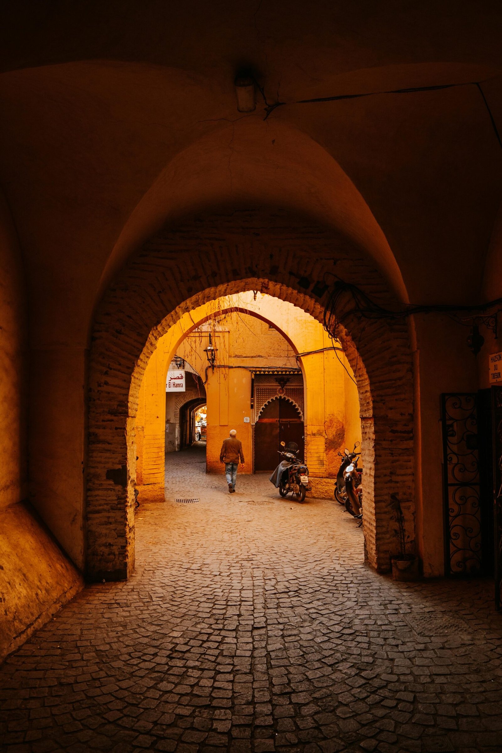 pexels-photo-30710066-30710066 A person walking through a historic archway in Marrakesh, Morocco.