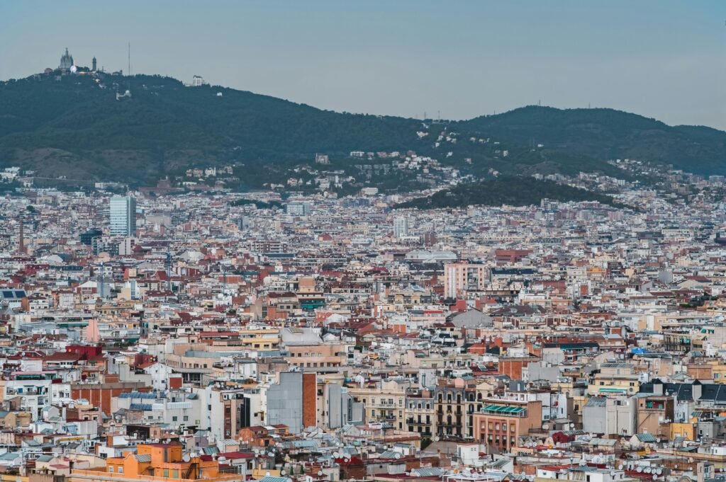 Expansive cityscape of Barcelona with mountains in the background.