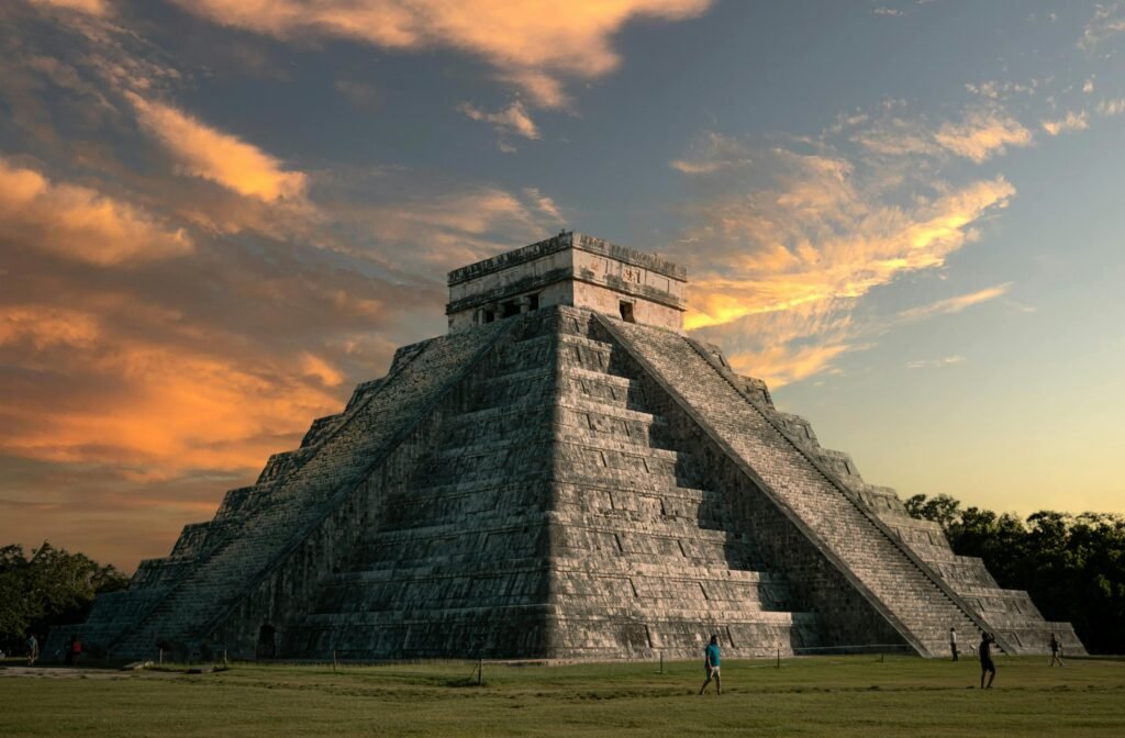 pexels-photo-5869131-5869131 Majestic view of El Castillo pyramid at Chichen Itza with a vibrant sunset sky.