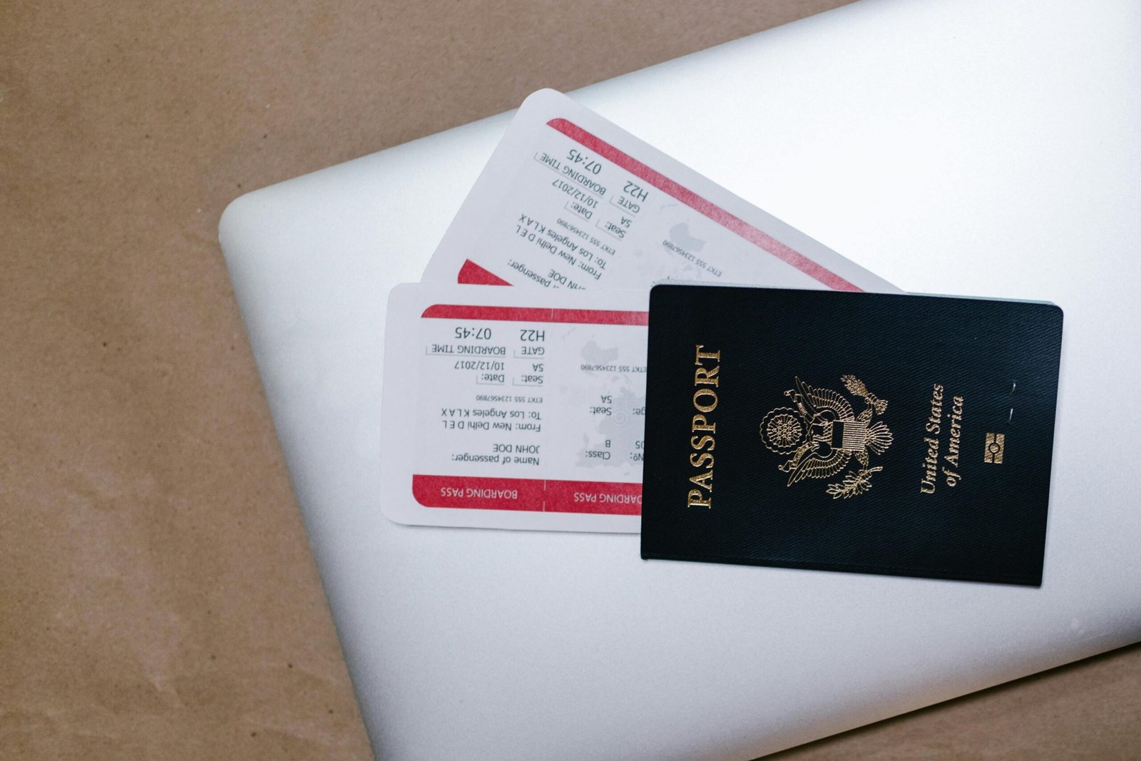 pexels-photo-7310015-7310015-1 Close-up of a passport and boarding passes on a laptop, symbolizing travel preparation.