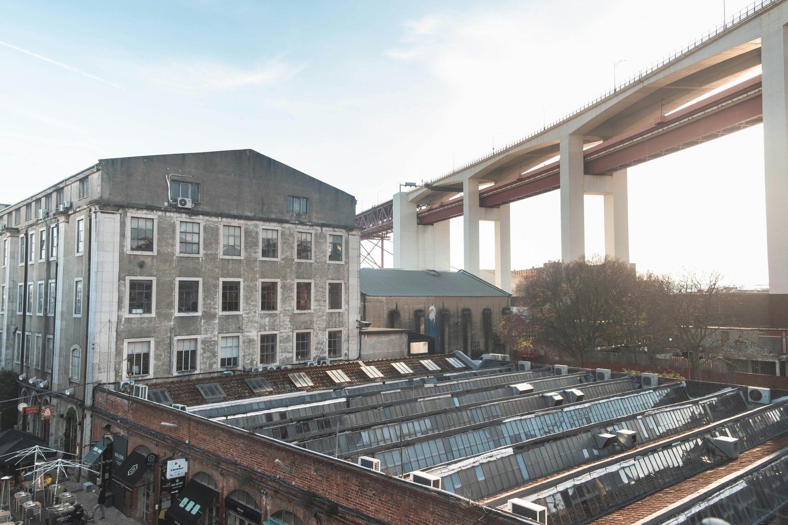 pexels-photo-10805106-10805106 View of industrial buildings and iconic bridge in Lisbon, Portugal.