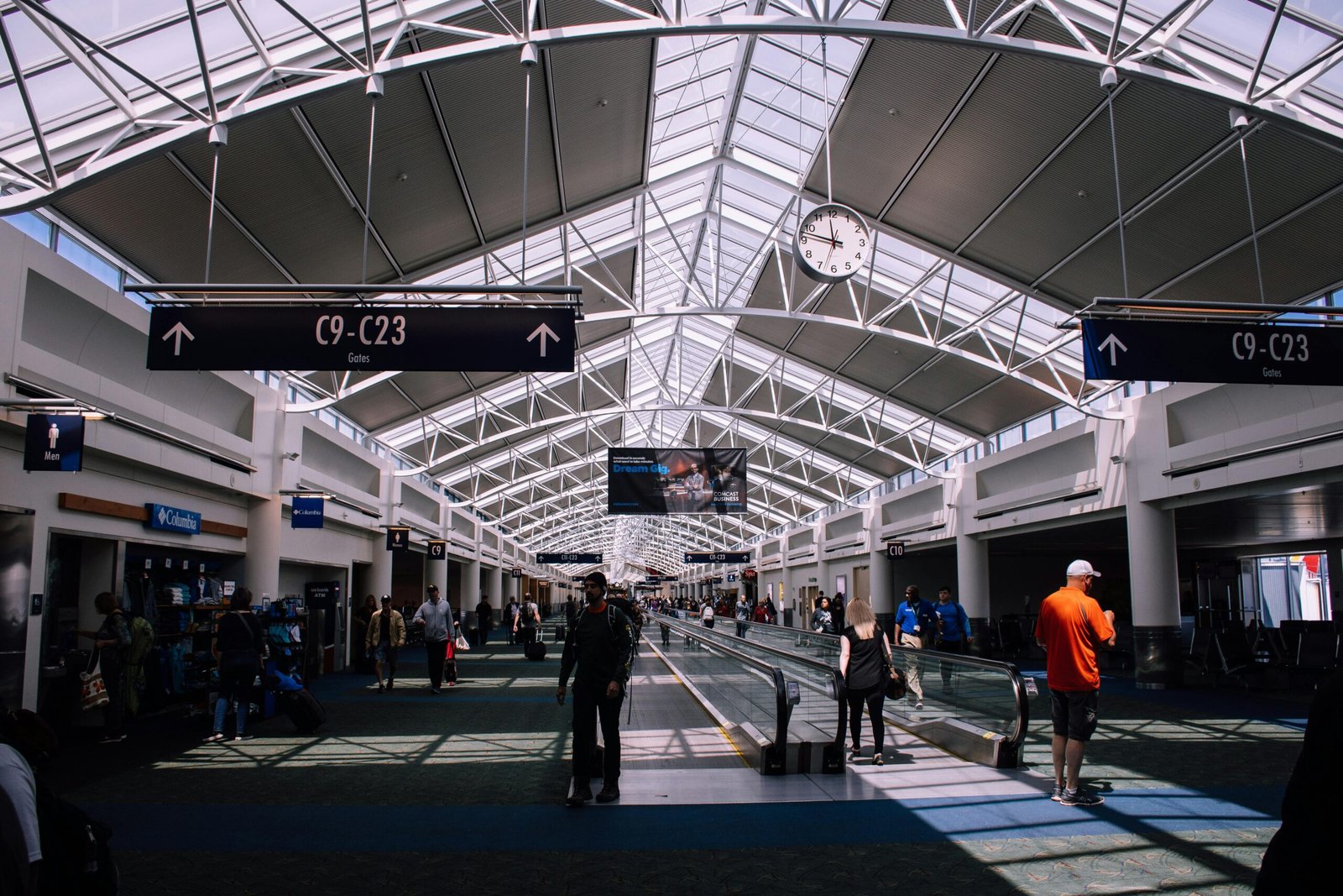pexels-photo-1115358-1115358 Spacious airport terminal with moving walkway and travelers, showcasing modern architecture.