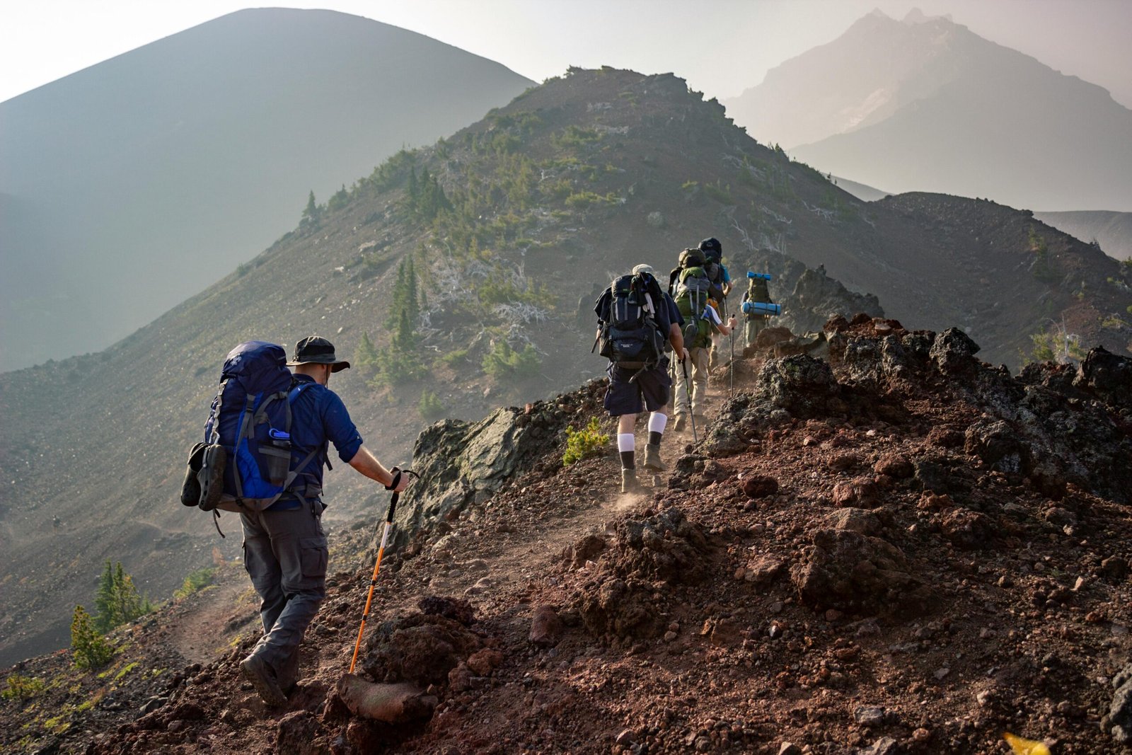 pexels-photo-1365425-1365425 Group of hikers trekking on a rugged mountain trail in Oregon's scenic outdoors.