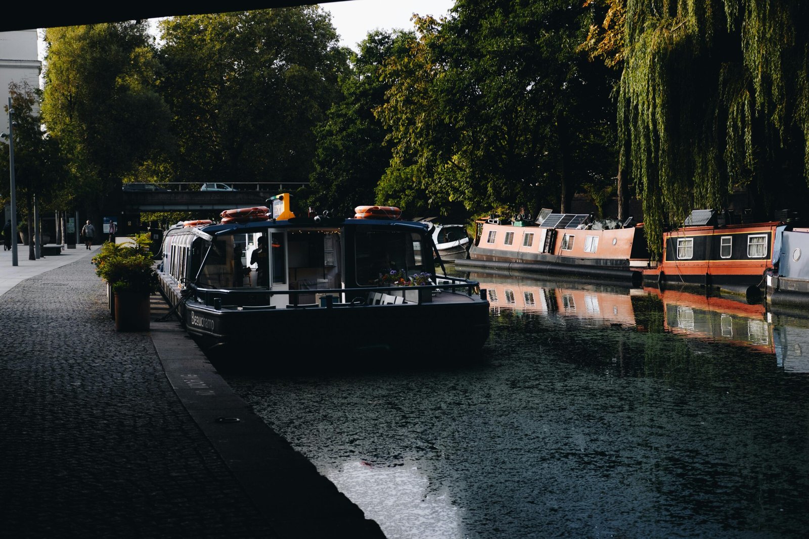 pexels-photo-19121494-19121494 Explore the serene beauty of London's Regent's Canal with colorful barges and leafy surroundings.