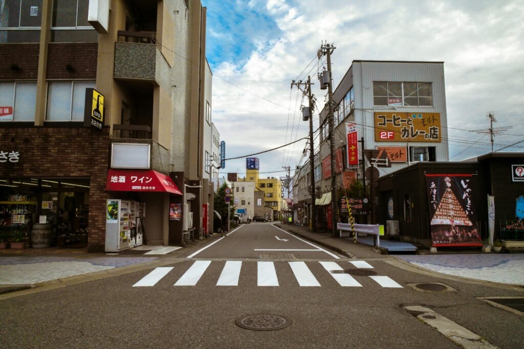 Vibrant urban street in Japan with buildings and a zebra crossing in view.