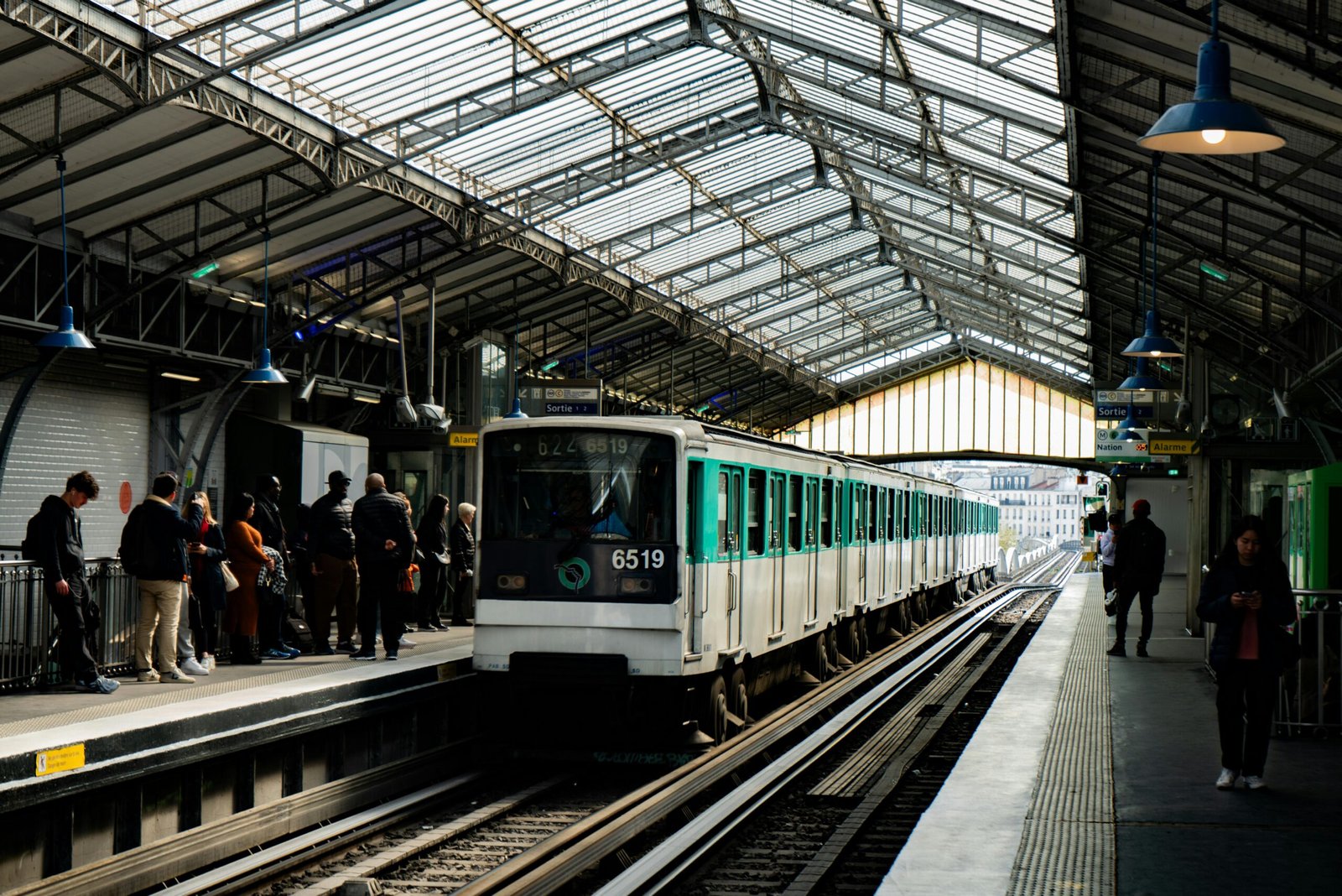 pexels-photo-29693532-29693532 A busy Paris metro station with a vintage train arriving as passengers wait on the platform.
