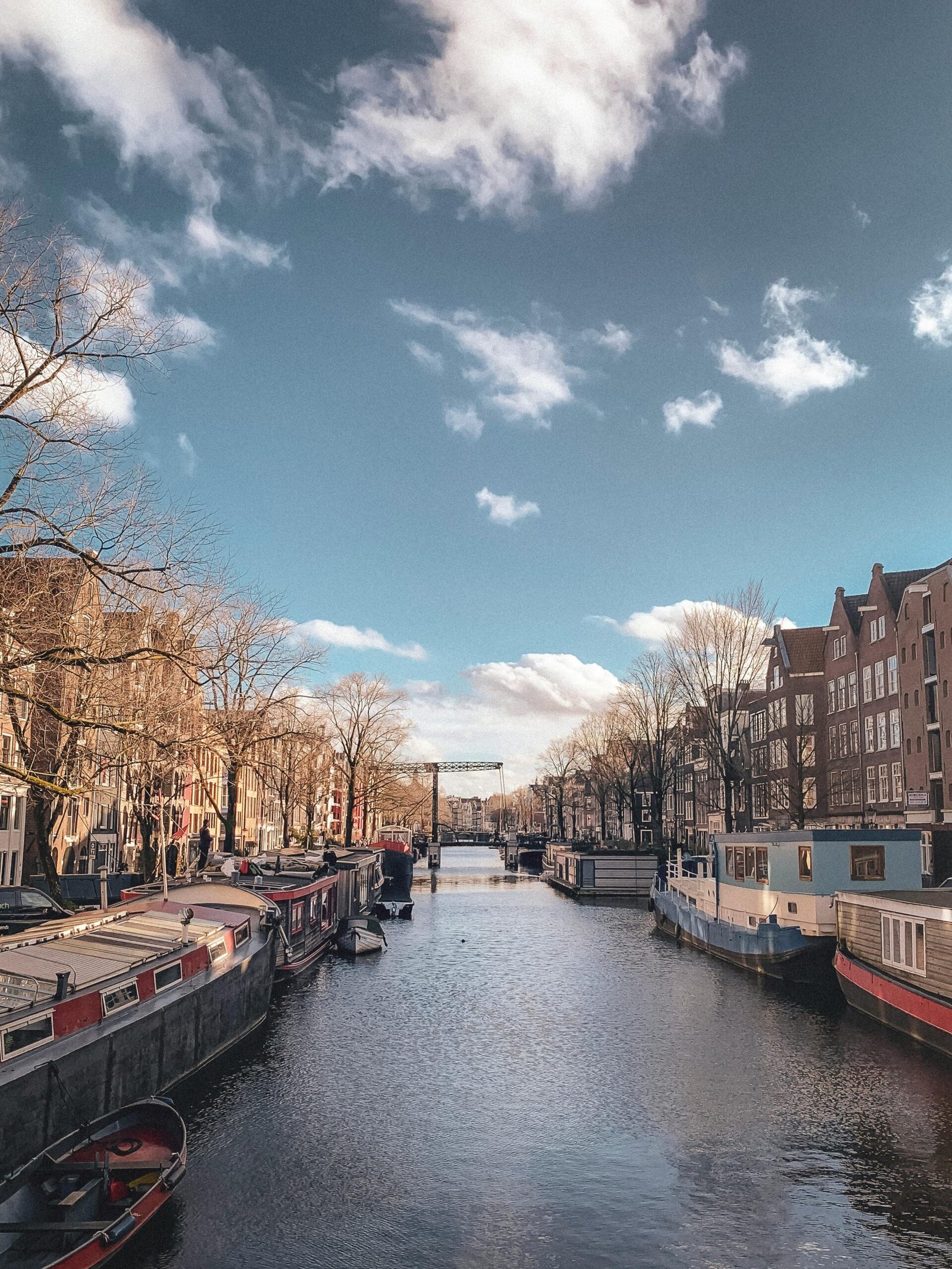 pexels-photo-30445495-30445495 Beautiful winter view of Amsterdam's canal lined with houseboats under a clear sky.