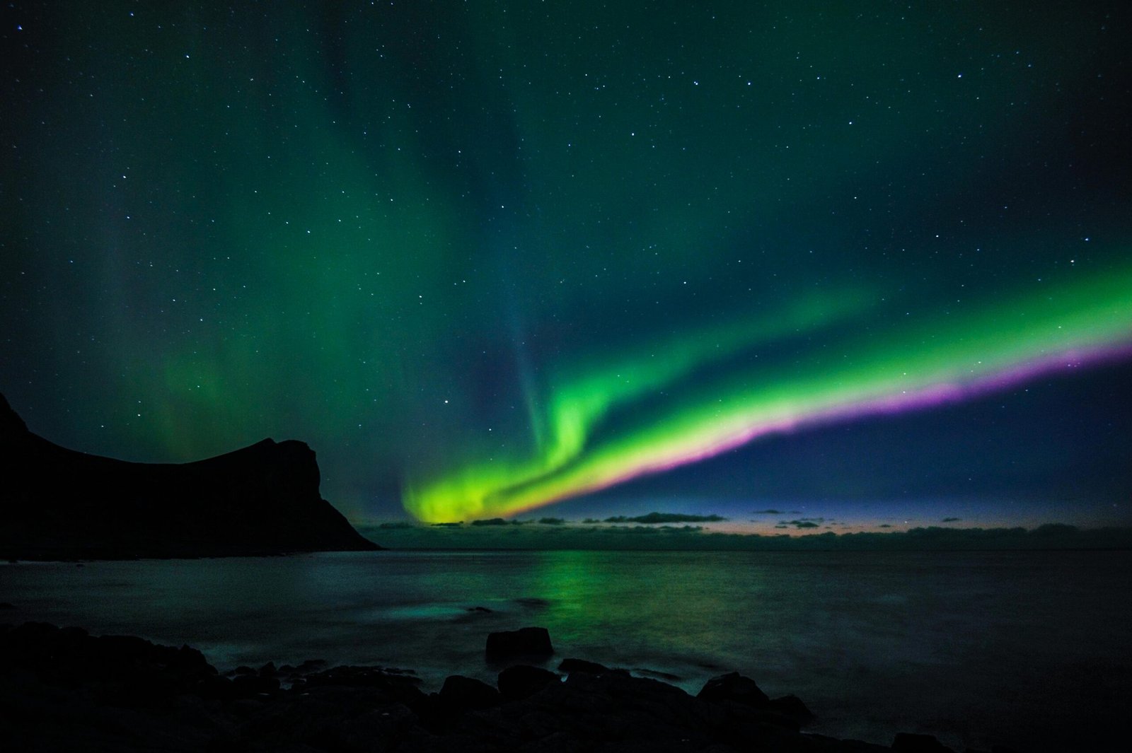 pexels-photo-3451755-3451755 Breathtaking display of Northern Lights over the sea at Myrland, Norway.