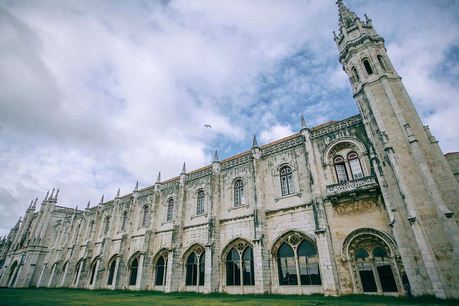pexels-photo-4917107-4917107 A stunning view of the historic Jerónimos Monastery in Lisbon, displaying gothic architecture against a cloudy sky.