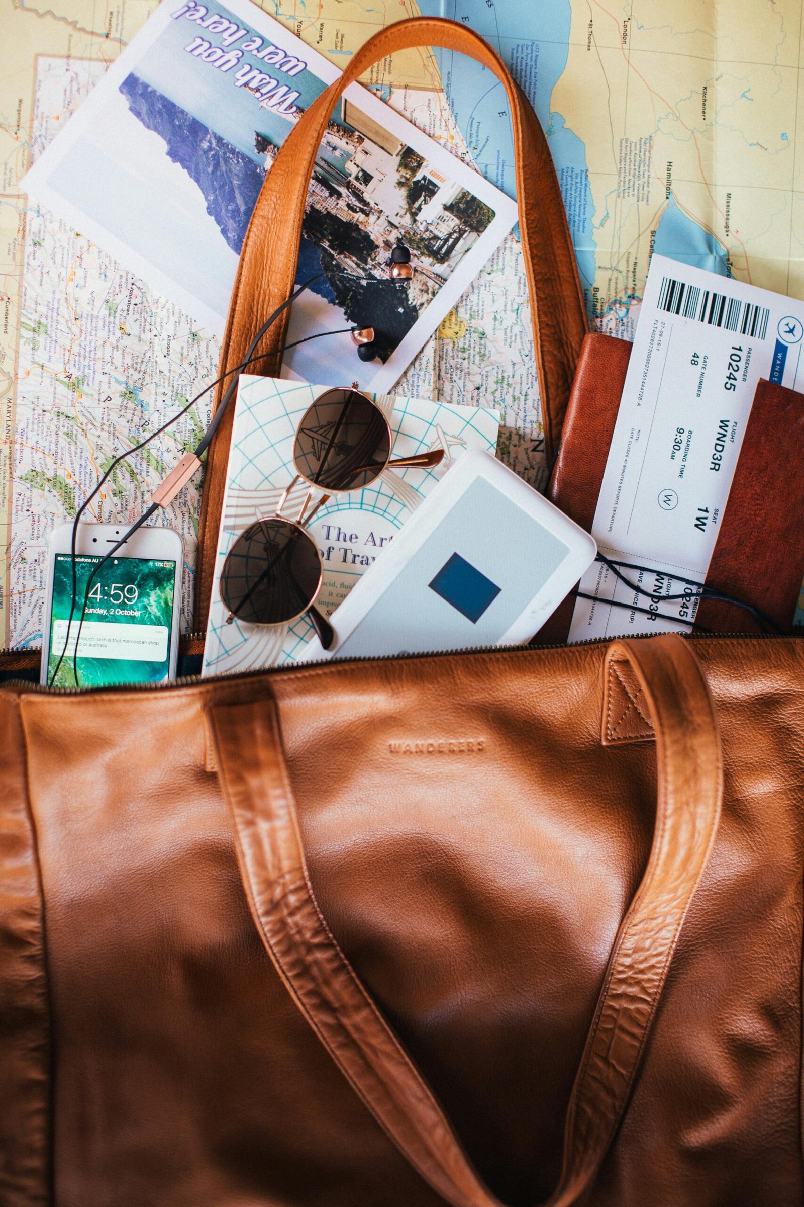 pexels-photo-5863541-5863541 Flat lay of travel essentials including a leather bag, map, sunglasses, and tickets.