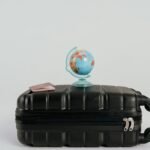 A globe placed on a black suitcase symbolizing global travel and adventure.