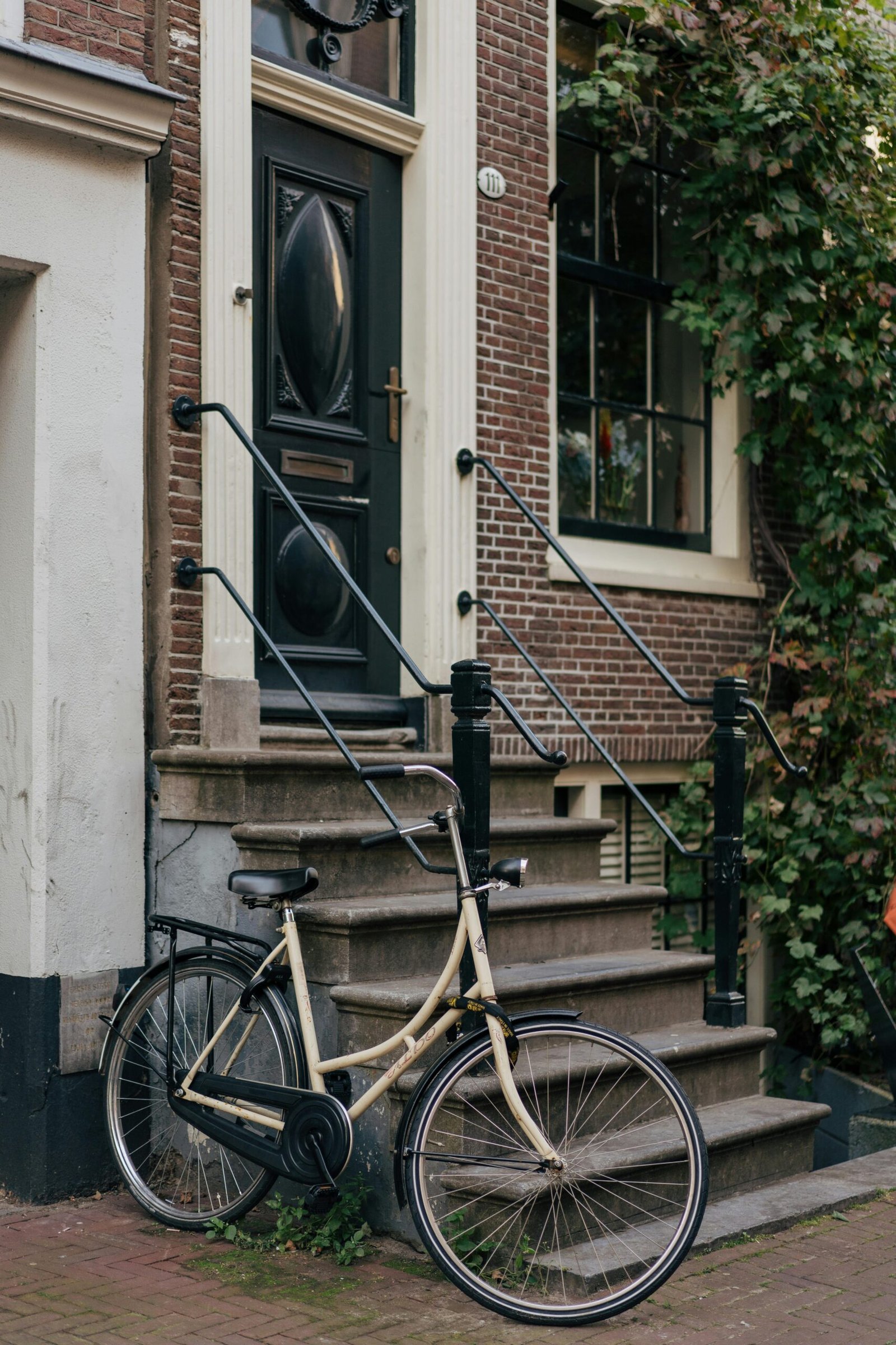 Charming Amsterdam street scene with a vintage bicycle against a traditional brick house.