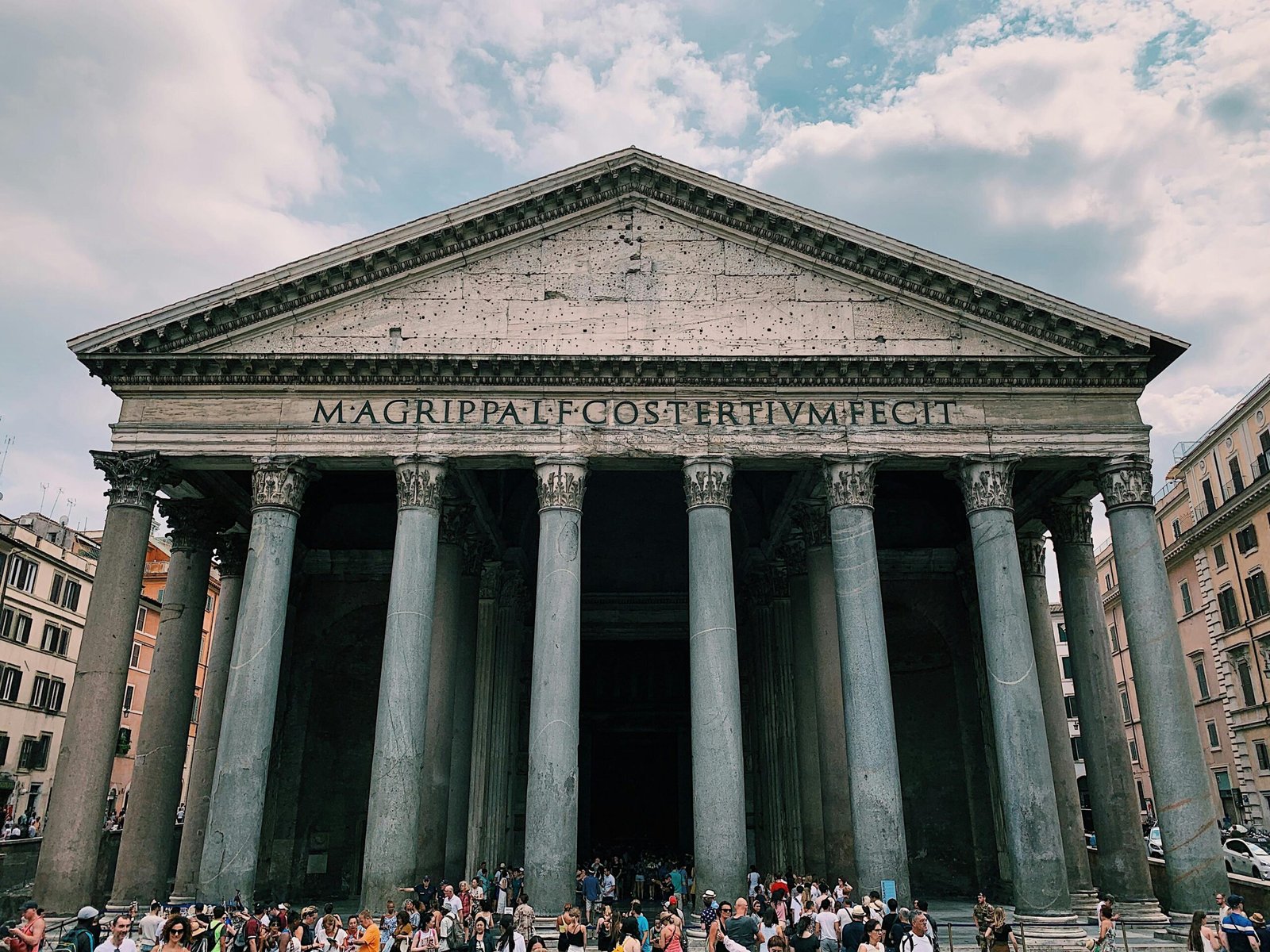 Front view of the Pantheon in Rome, Italy with tourists gathering at the entrance.