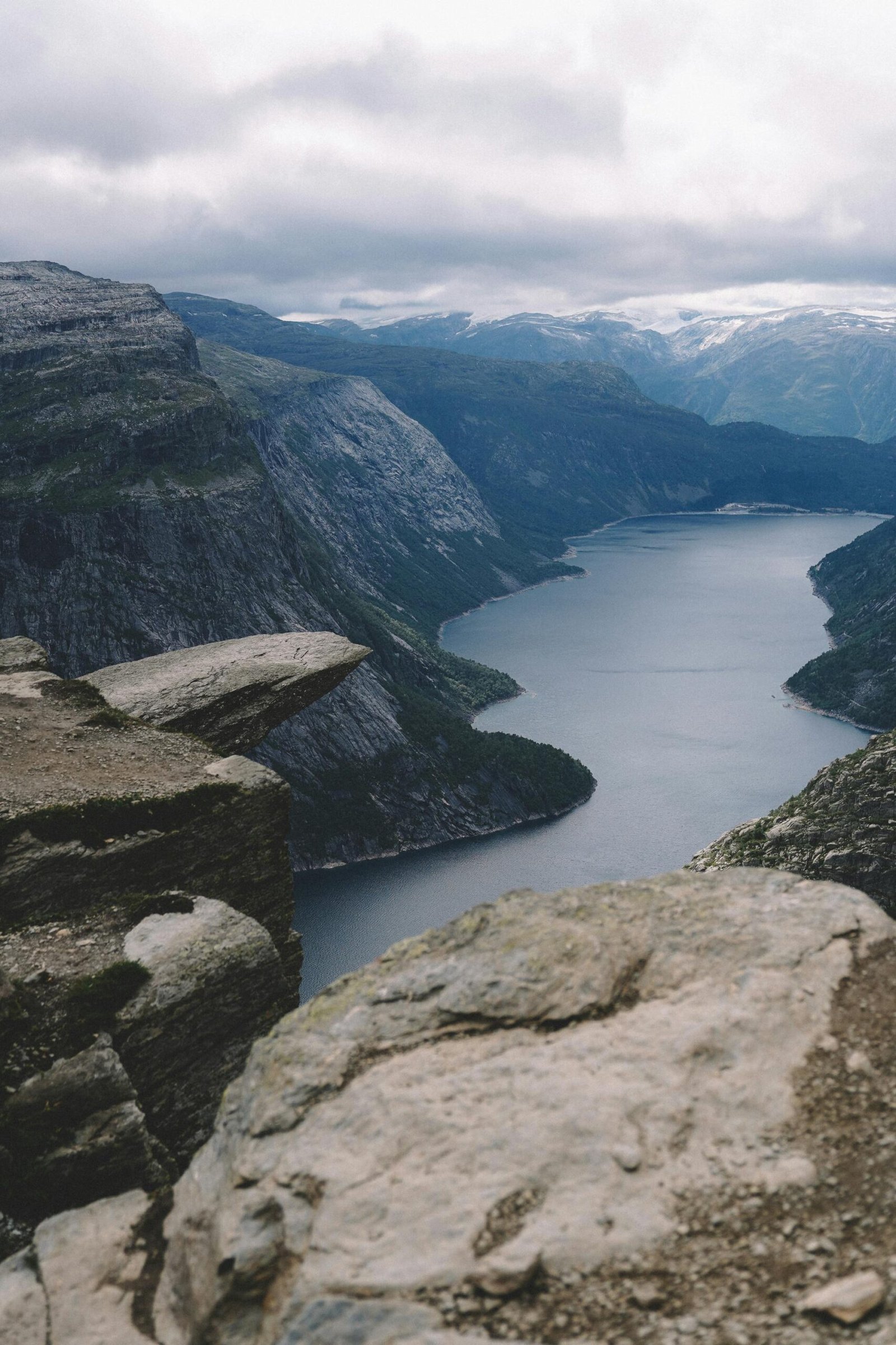 Stunning view of a fjord surrounded by steep cliffs and cloudy sky, perfect for nature enthusiasts.