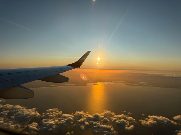 Capture of a mesmerizing ocean sunset viewed from an airplane window during flight.
