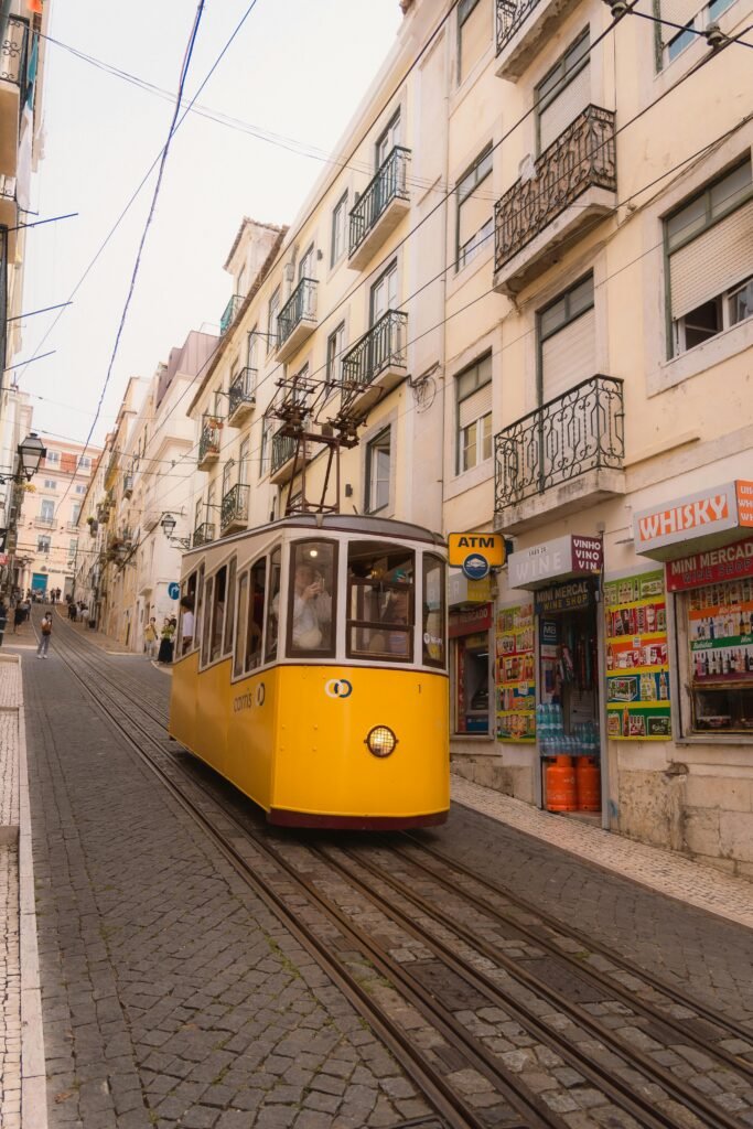 Charming yellow tram navigating the historic streets of Lisbon, Portugal on a sunny day.