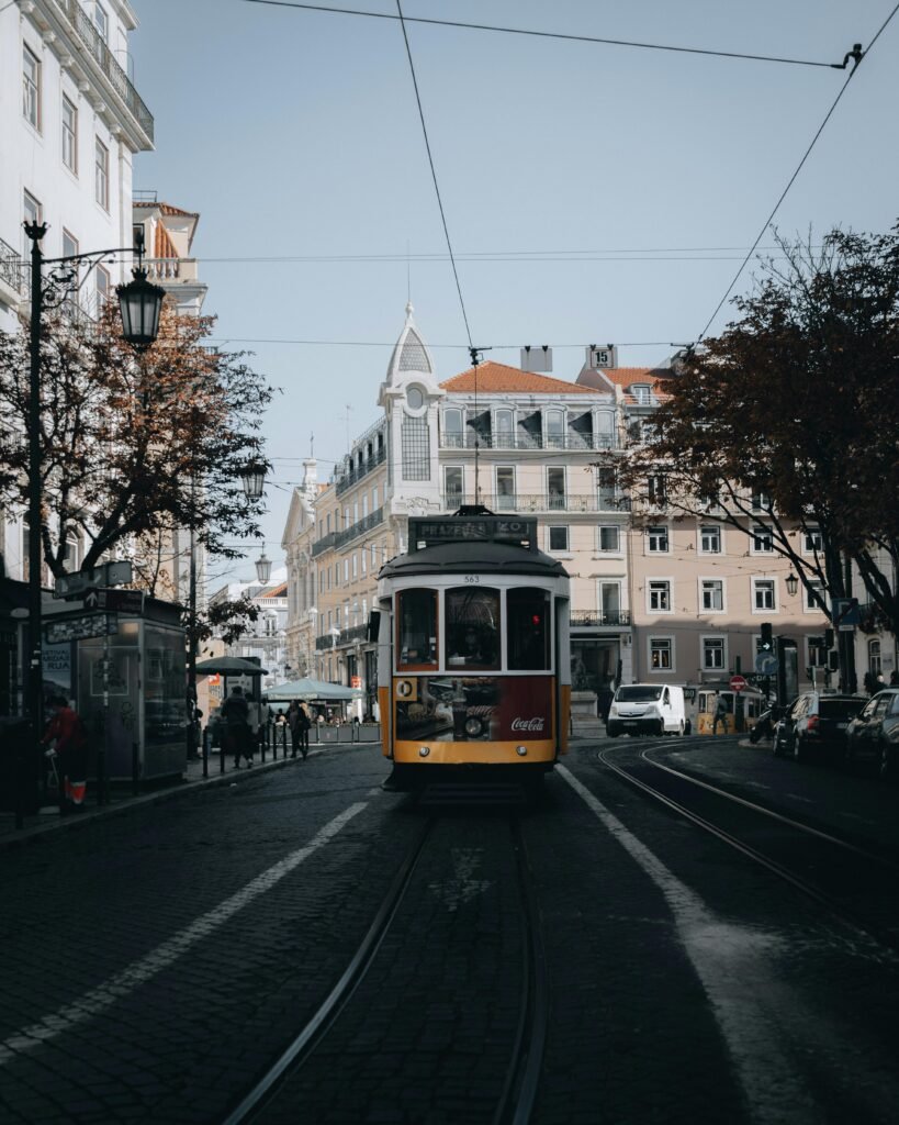 Iconic Lisbon yellow tram traveling through historic downtown, capturing the city's charm.