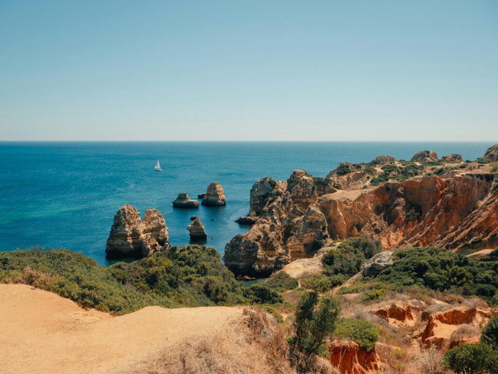 Beautiful Algarve coastline with rugged cliffs and calm blue sea in Faro, Portugal.
