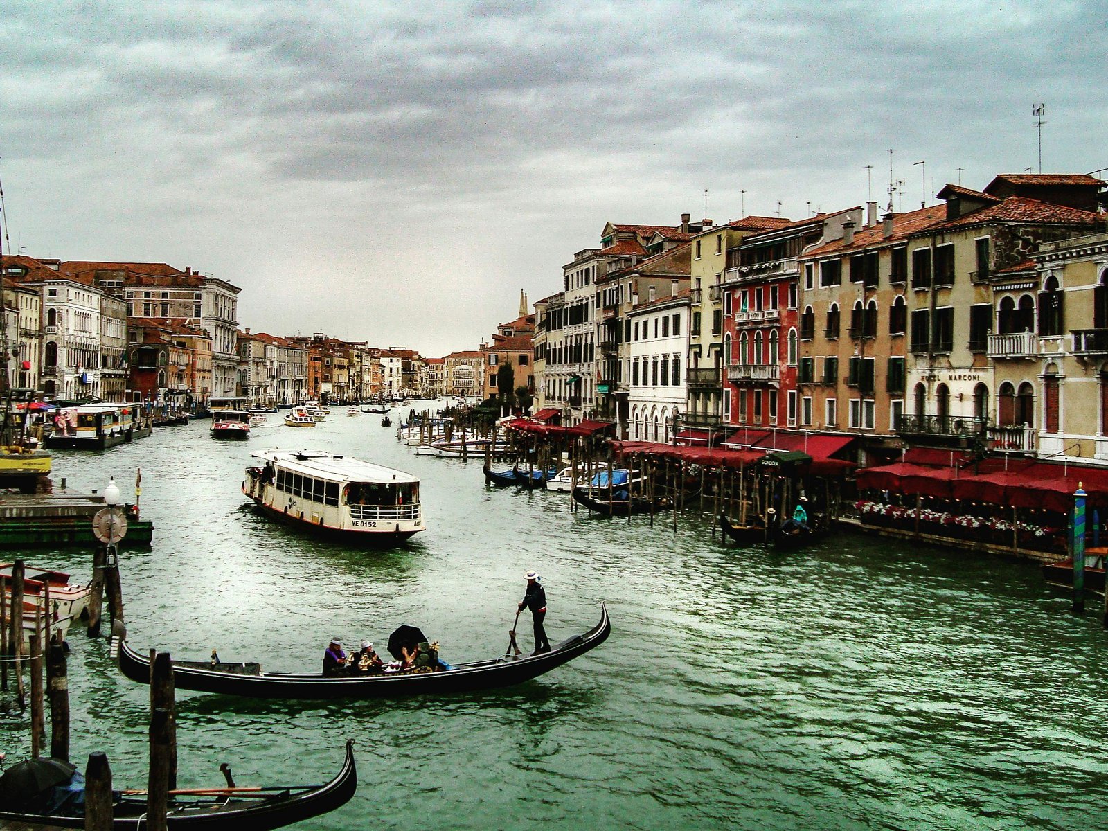 Idyllic scene of gondolas and boats on the Grand Canal in Venice, Italy with historic buildings lining the waterfront.